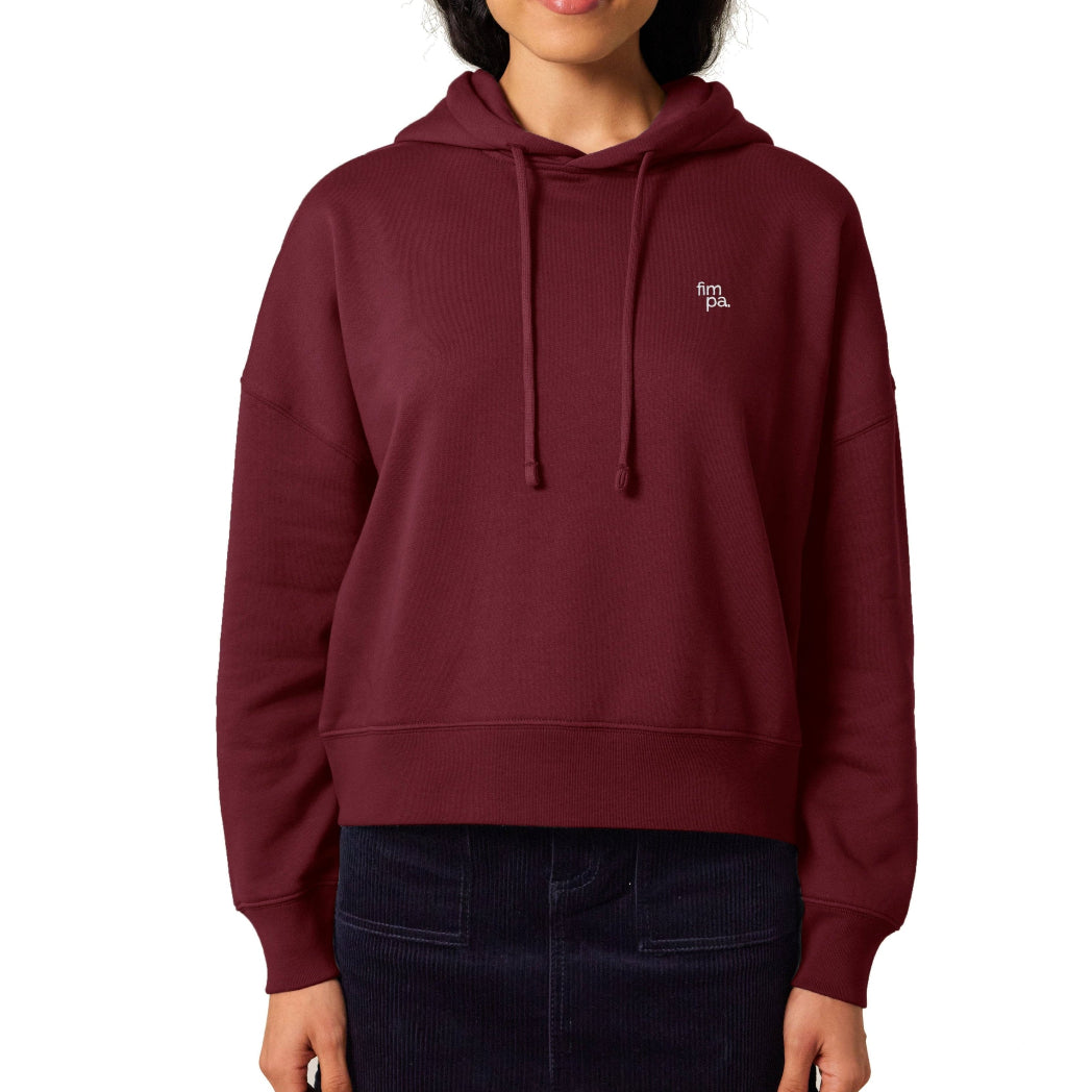 Burgunderfarbener Damen Hoodie mit weißem Sticklogo nachhaltig und fair, kombiniert mit einem schwarzen Rock.