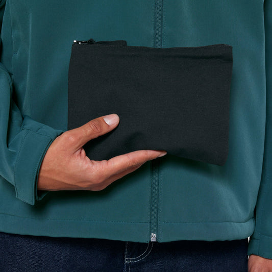 Schwarze nachhaltige Stofftasche in kompakter Größe, gehalten von einer Person in Outdoor-Jacke – ideal für umweltfreundliches und minimalistisches Zubehör.