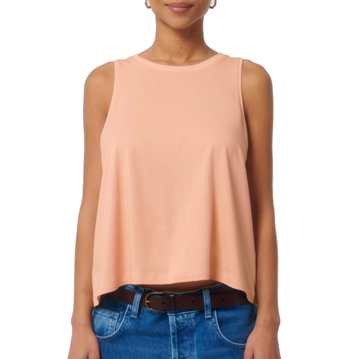 Pfirsichfarbenes ärmelloses Top im Relaxed Fit, aus 100% gekämmter ringgesponnener Bio-Baumwolle – kombiniert mit blauen Jeans.