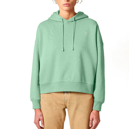 Mintgrüner Damen-Hoodie mit weißem Stick-Logo kombiniert mit einer beigefarbenen Hose.