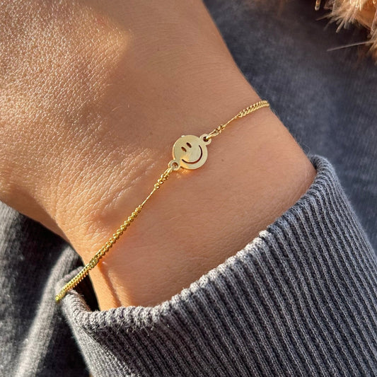 Goldenes Smile Armband am Handgelenk getragen – 18 Karat vergoldeter Edelstahlschmuck von fimpa.