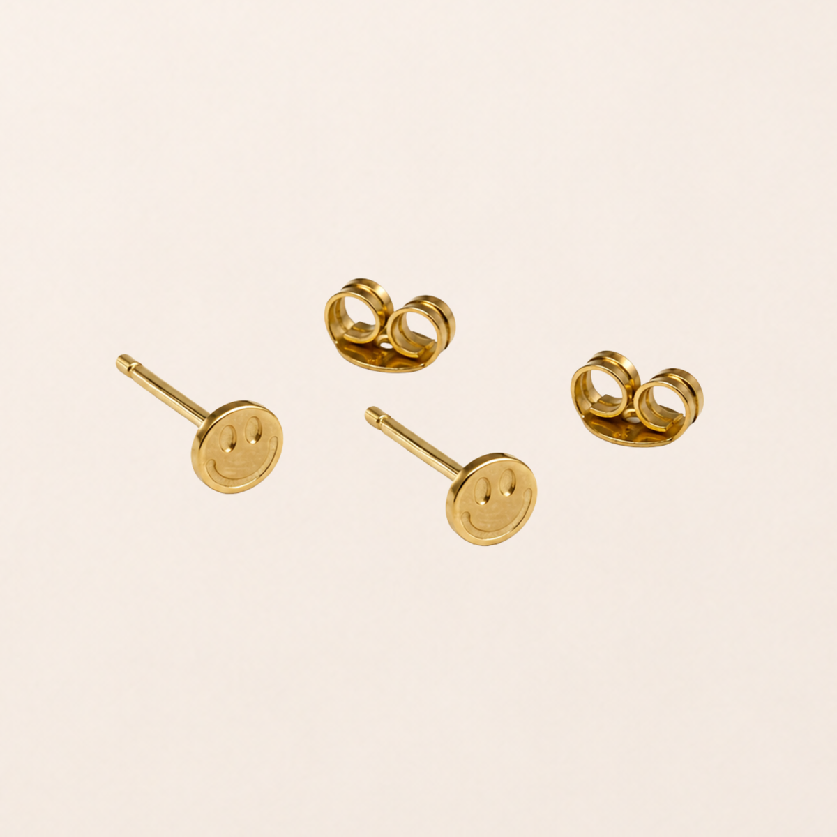 Smile Ohrstecker 18k vergoldet – goldene Smiley-Ohrstecker auf grünem Hintergrund | fimpa.