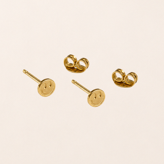 Smile Ohrstecker 18k vergoldet – goldene Smiley-Ohrstecker auf grünem Hintergrund | fimpa.