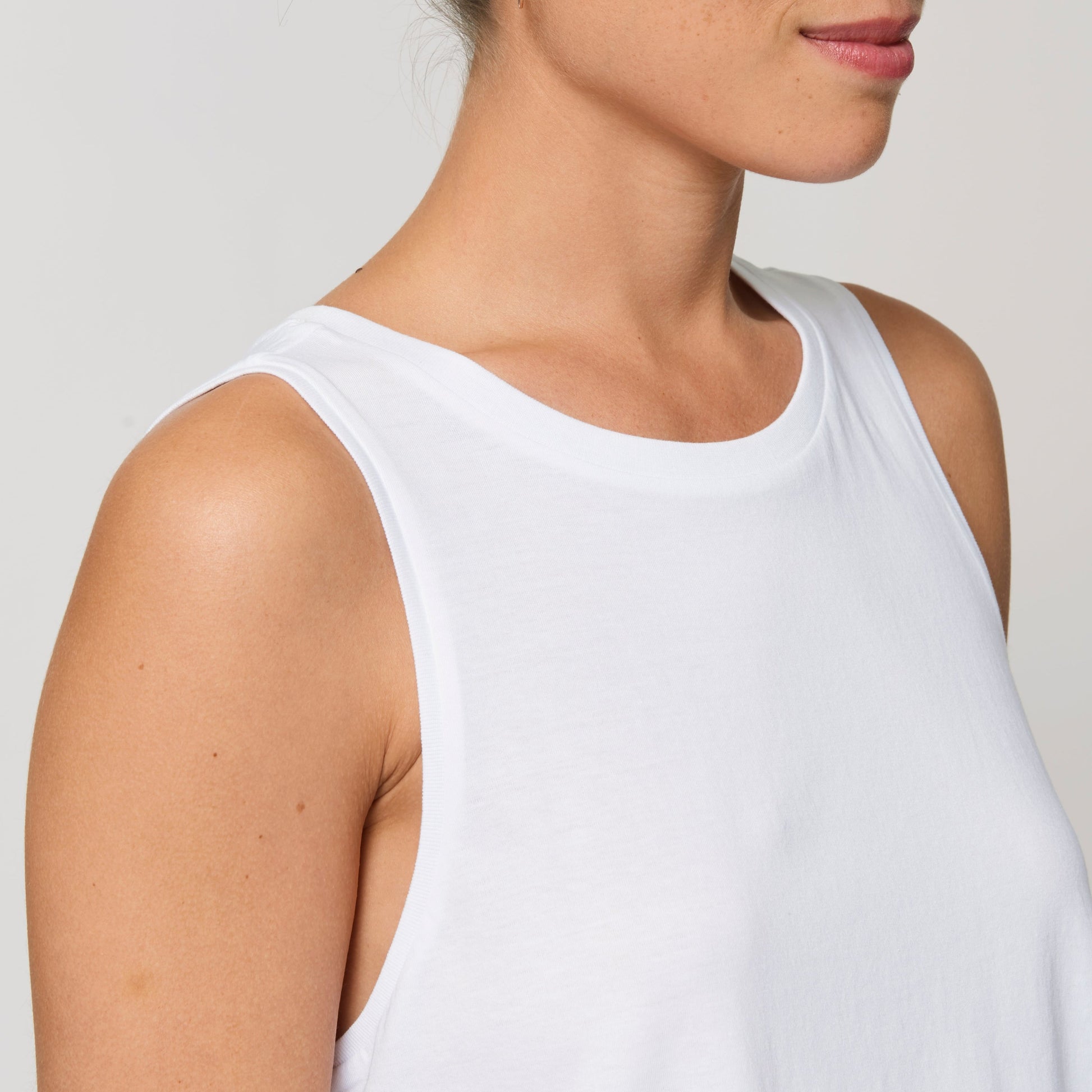 Detailansicht eines ärmellosen weißen Tops im Relaxed Fit, aus glattem und leichtem Singlerjersey.