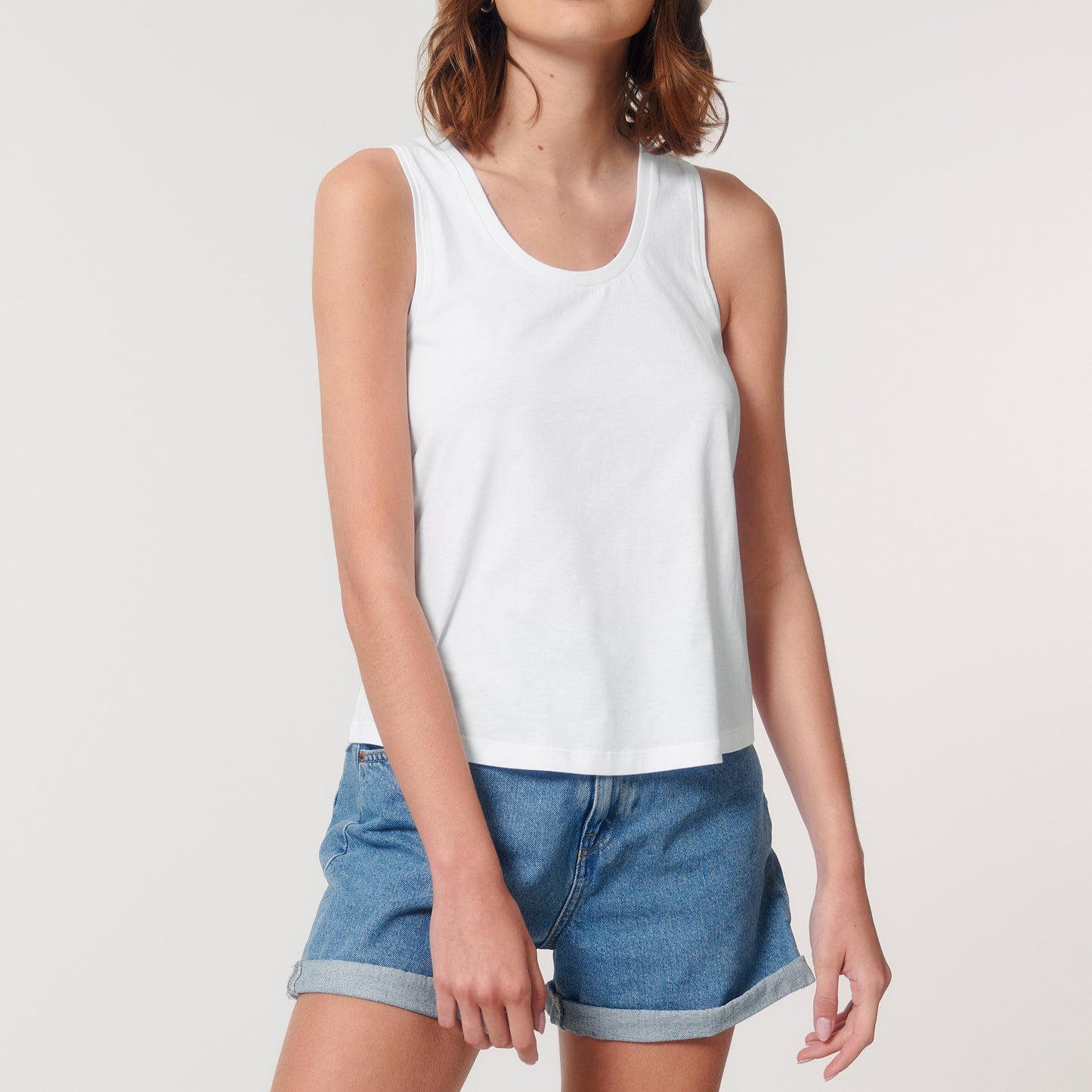 Weißes Basic Tank-Top mit kurzer Jeans Hose kombiniert.