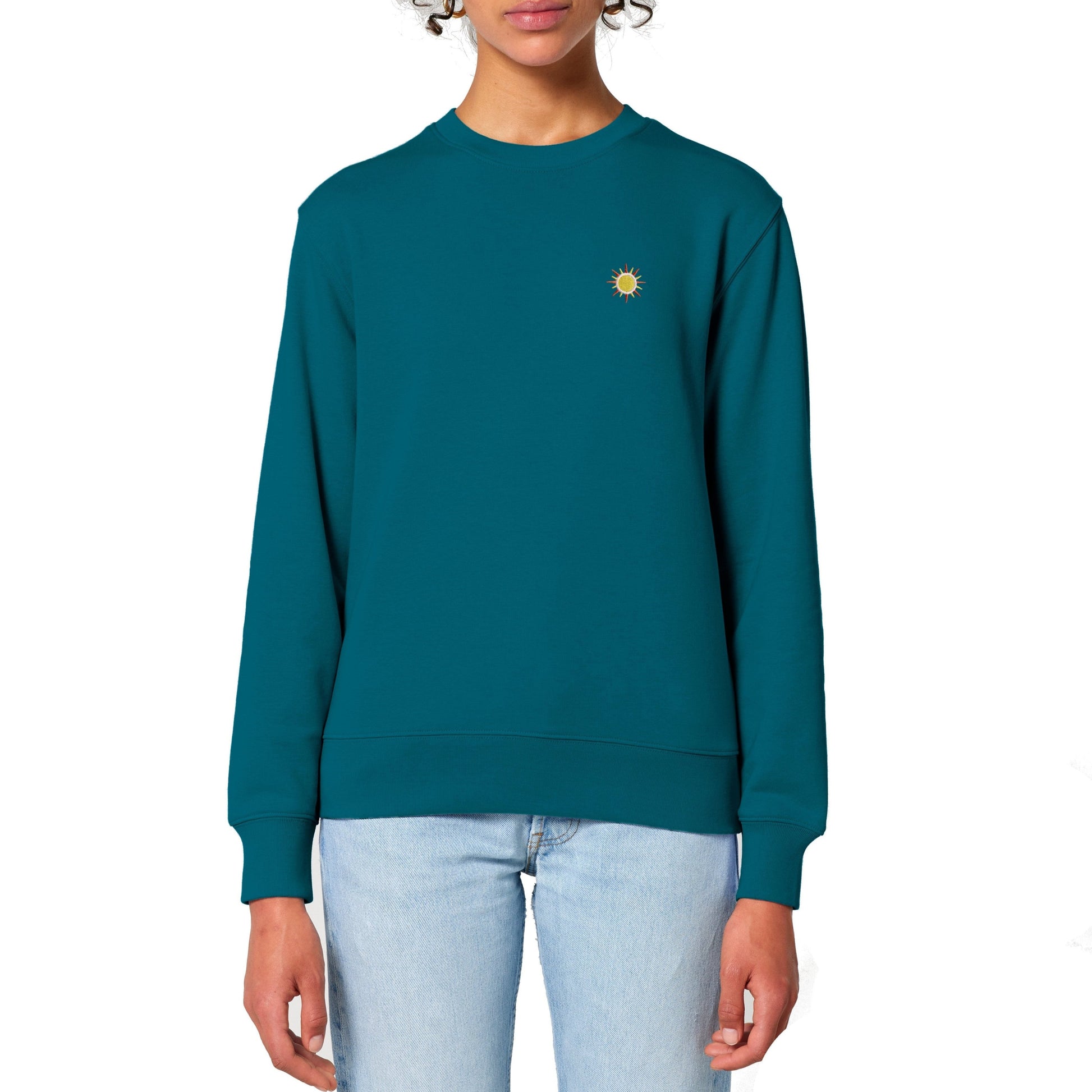 Frau trägt ein Unisex Regular Fit Terry Sweatshirt in Blau mit gesticktem Sonnen-Motiv, weich und stylisch